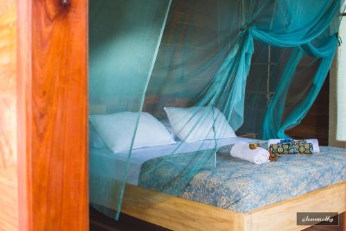 a bed with two stuffed animals sitting on it at Tevana House Reef in Bira