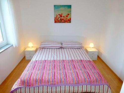 um quarto com uma cama grande e 2 mesas de cabeceira em Apartments Kvesić em Šilo