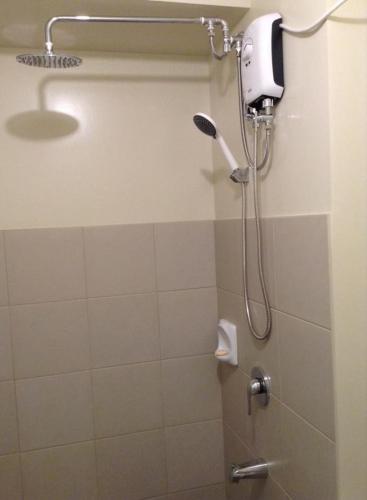 a shower in a bathroom with a shower head at Davao Avida Towers in Davao City