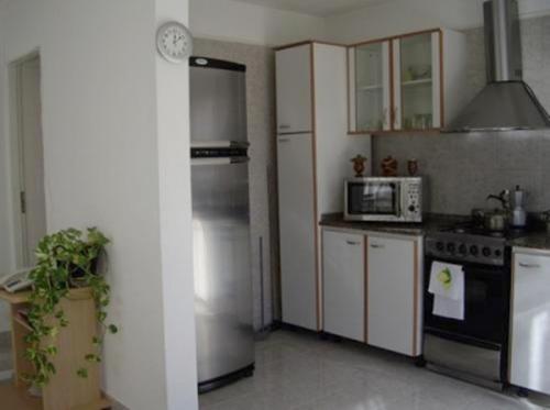 a kitchen with a refrigerator and a stove top oven at Complejo Marce in Ostende