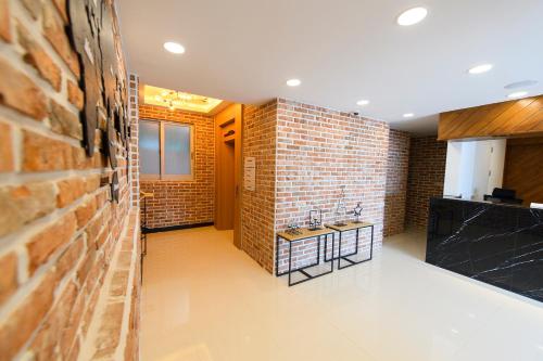 a kitchen with two sinks and a brick wall at Busan Station BUSAN VIEW HOTEL in Busan
