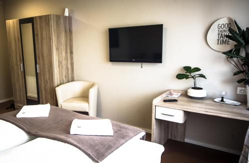 a room with two beds and a tv on the wall at Cafe-Restaurant LEO in Kalsdorf bei Graz