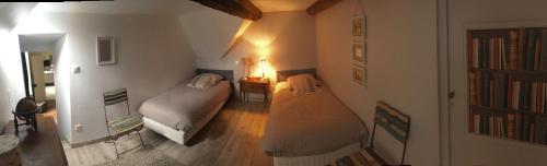 a small bedroom with two beds and a lamp at Gite "Le Havre de Marie" in Lailly-en-Val