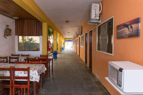 um corredor de um restaurante com mesas e um micro-ondas em Pousada Mar Virado em Ubatuba