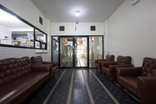 a waiting room with brown leather couches and a lobby at Monta Apartment in Bangsaen