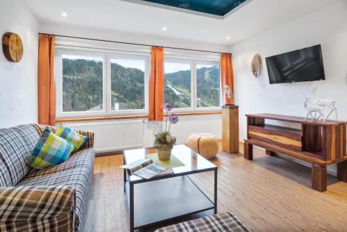 a living room with a couch and a table at Zur Schönen Aussicht Hotel garni in Garmisch-Partenkirchen