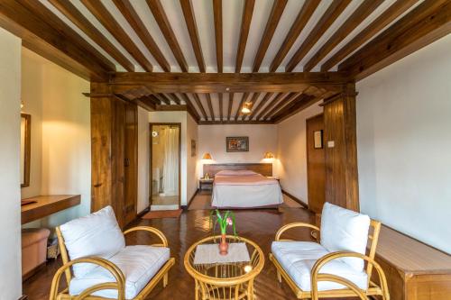 加德滿都的住宿－康提普寺廟別墅，酒店客房带一张床、一张桌子和椅子