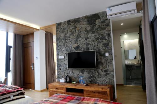a room with a television on a stone wall at Beyond the Terrace Residence in Yuanyang