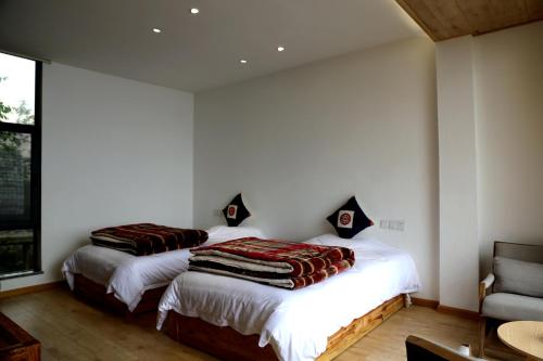 two beds in a room with white walls at Beyond the Terrace Residence in Yuanyang