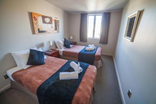 a hotel room with two beds in a room at City Central Motel Apartments in Christchurch