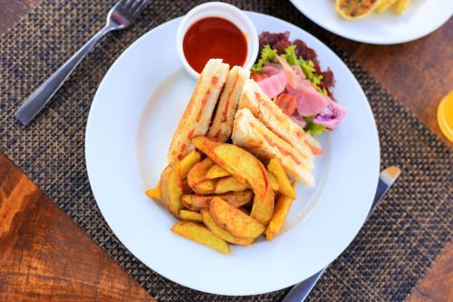 a plate of food with a sandwich and french fries at The Forest and Lake by Schofieldshire in Nuwara Eliya
