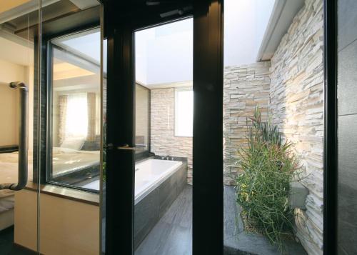 a bathroom with a bath tub and a window at Hotel Emit Ueno in Tokyo