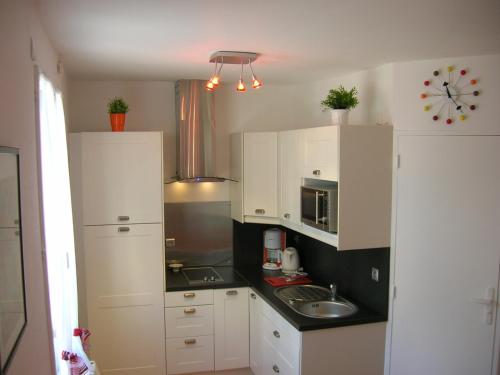 索特維爾魯昂的住宿－Gite A，小厨房配有白色橱柜和水槽