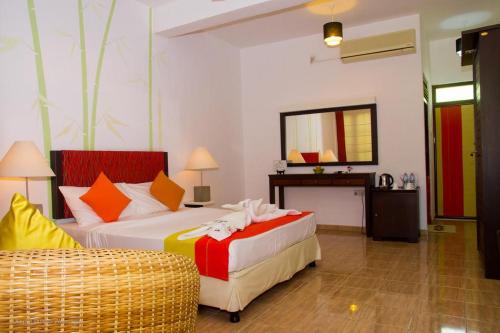 a hotel room with two beds and a mirror at The Kent in Tissamaharama