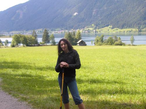 a woman is standing on a path with poles at Haus Birke in Weissensee