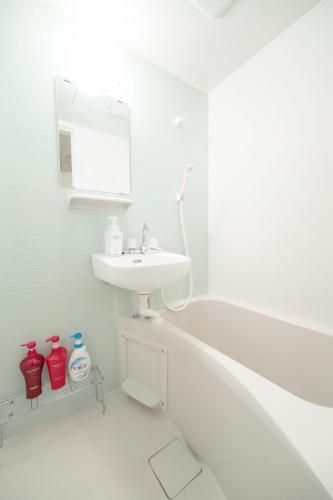 a white bathroom with a sink and a bath tub at NTH Namba - Whole floor 3 flats - Self Check-In Only in Osaka
