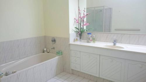 a white bathroom with a tub and a sink and a bath tubermott at Springwood Meditation Centre 春木禪修渡假中心 in Springwood