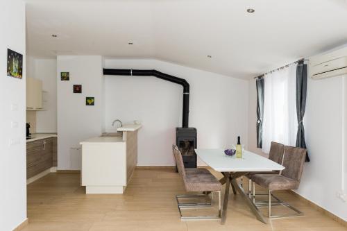 - une cuisine et une salle à manger avec une table et des chaises dans l'établissement Apartments Sky, à Šibenik