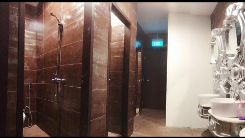a bathroom with a shower and a toilet and a sink at Atlantis Pods @ Little India in Singapore