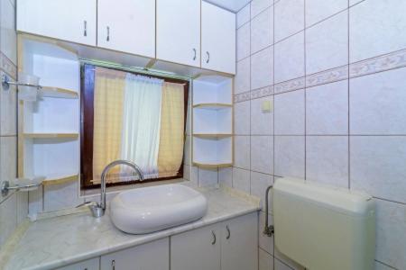 a white bathroom with a sink and a window at Chalets Bogo & Neno in Ledenice