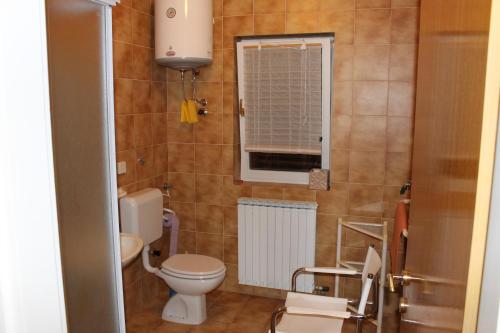 a small bathroom with a toilet and a window at Apartments Vila Marica in Rabac
