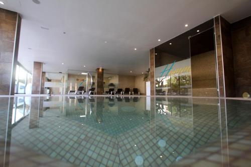 un vestíbulo con piscina en medio de un edificio en Apartamentos Cambrils Playa Spa, en Cambrils