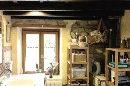 a kitchen with a tub and a stone wall at El Cuetu in Posada