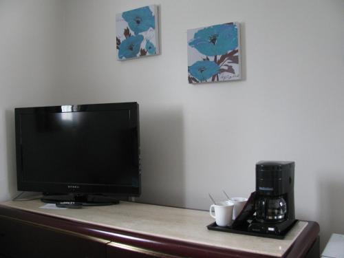 a television sitting on top of a desk with a coffee maker at Motel de l'Outlet in Magog-Orford