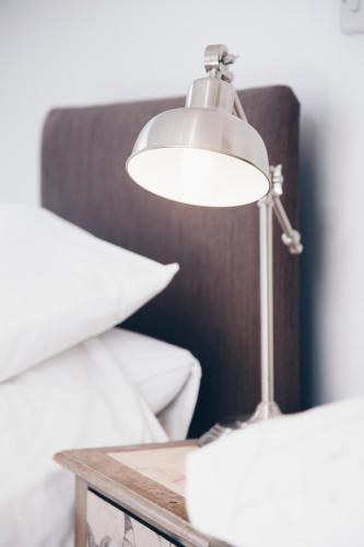 a lamp sitting on a table next to a bed at Quay Quarters in Chichester