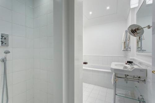 a white bathroom with a sink and a shower at Anna Belle Elegant AgriResort in Sorrento