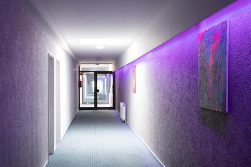 a hallway with purple walls and a purple hallway at Confour Hotel in Burgdorf