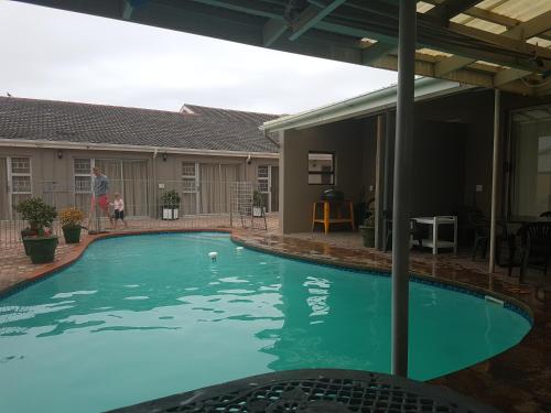 una persona de pie junto a una piscina en Marine48 Self-catering Port Elizabeth, en Port Elizabeth