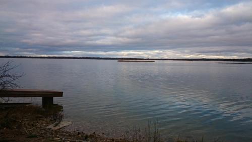a view of a lake with a wooden bench at Seaside cottage in Kõiguste