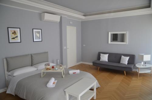 a white bedroom with a bed and a couch at Room 56 in Bari