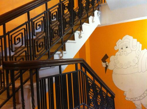 a staircase with a mural of a chef on the wall at Zeus Hostel in Athens