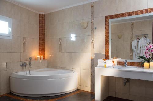 a bathroom with a tub and a sink at Grand Beach Hotel in Mýkonos City