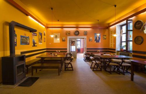 a restaurant with tables and chairs and a fireplace at Hotel Na Kocandě in Želiv