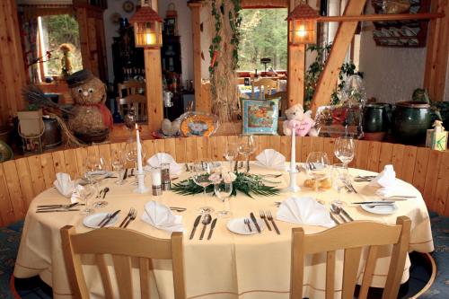 - une table à manger avec une nappe et des chaises blanches dans l'établissement Wolffhotel, à Kopp