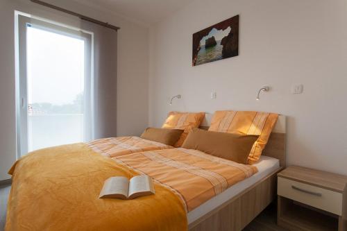 a bedroom with a bed with two books on it at Villa Milohnici Florian in Milohnići