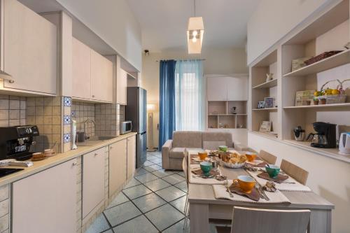 Il comprend une cuisine et un salon avec une table et des chaises. dans l'établissement Residenza Santa Lucia a Mare, à Naples