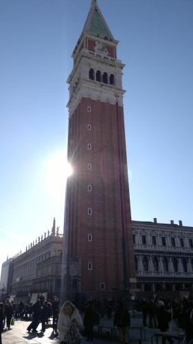 a tall clock tower in front of a building at Hotel AMALFI in Lido di Jesolo