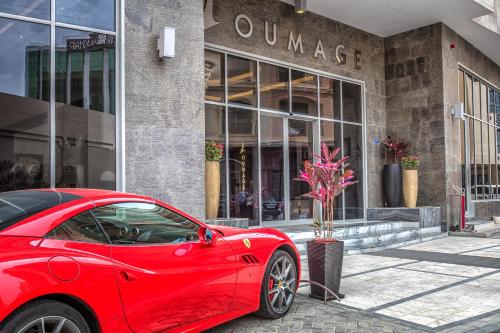 um carro vermelho estacionado em frente a um edifício em Loumage Suites and Spa em Manama
