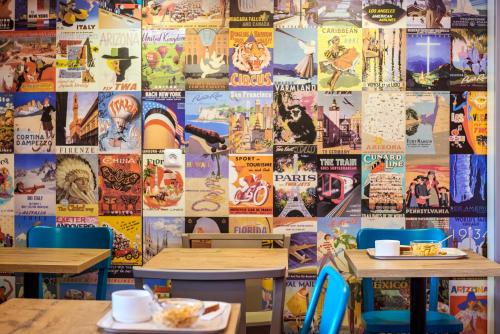 a restaurant with two tables and a wall covered in posters at hotelF1 Marseille EST in Marseille