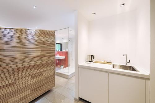 a kitchen with a sink and a wooden door at Hotel Rommel in Korb