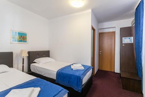 a hotel room with two beds with blue sheets at Casa Sofia in Bucharest