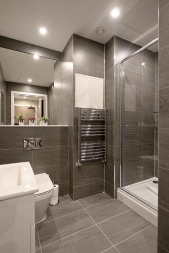 a bathroom with a toilet and a shower and a sink at Nelson Mandela Place Apartments in Glasgow