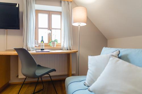 a bedroom with a blue couch and a desk with a window at Weingut Schauer in Kitzeck im Sausal