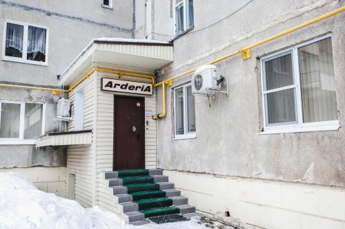 una puerta a un edificio de apartamentos con una escalera verde en Гостиница Arderia, en Ufa