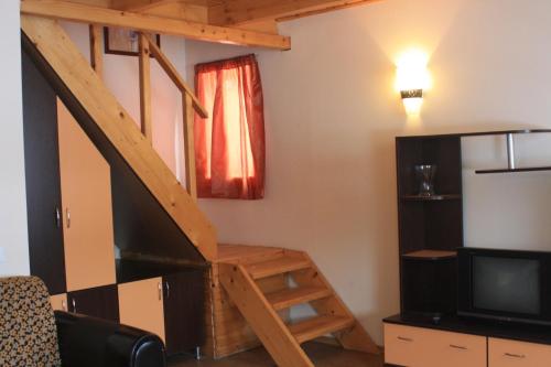 a living room with a staircase and a television at Lacul Racilor in Olimp