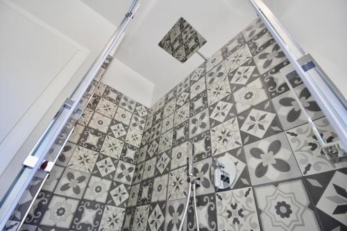 a bathroom with black and white tiles on the wall at Pepe Nero in Bordighera